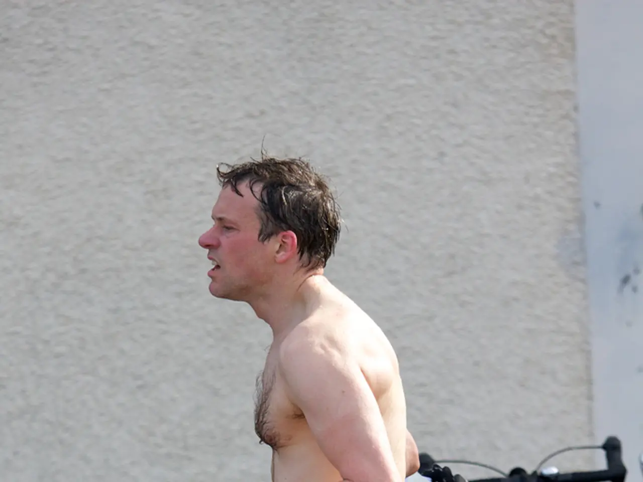 In this image we can see a person walking. In the back there are cycles. On the cycles there are...