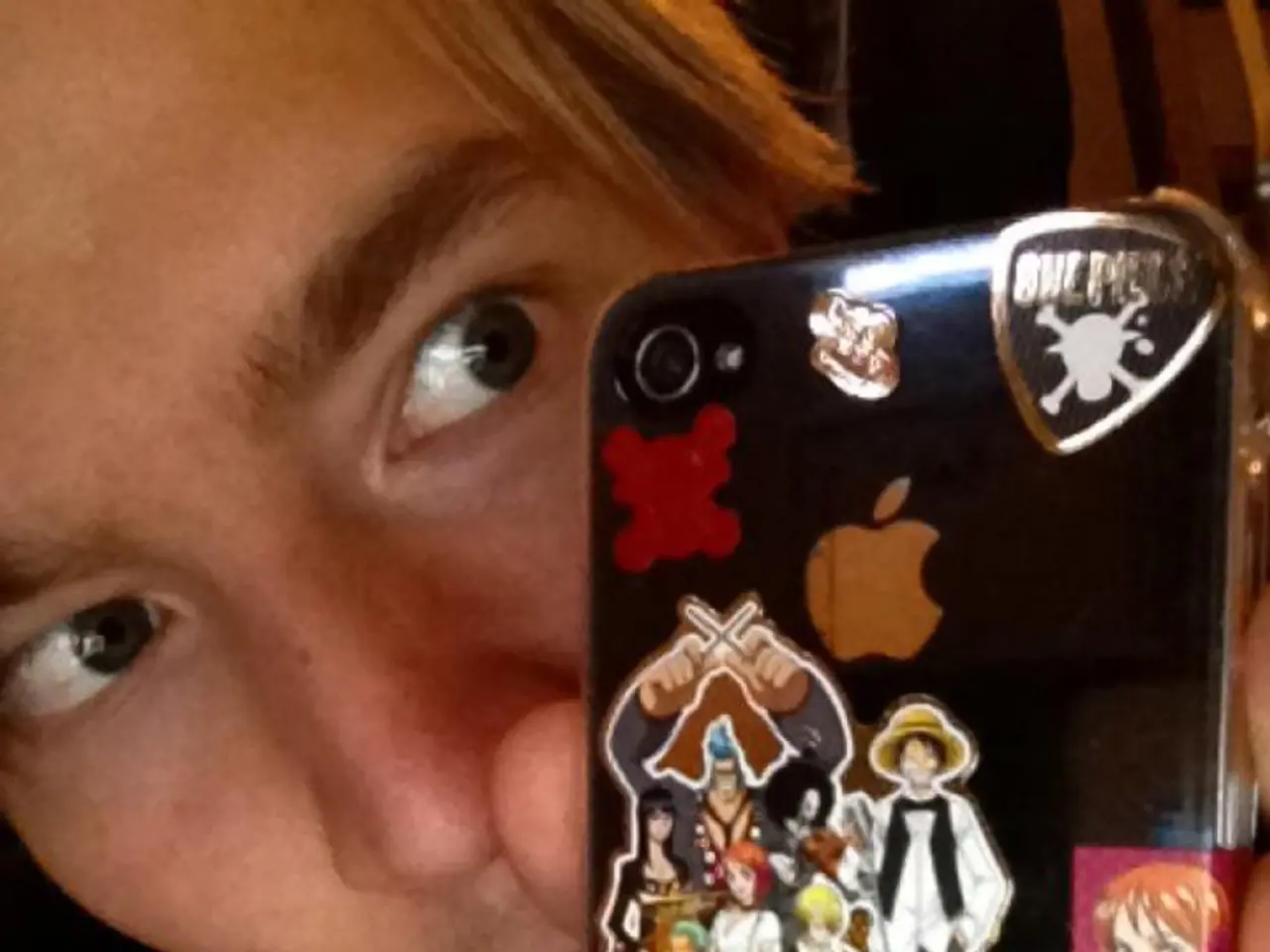 Boy in white t-shirt and black jacket is holding a mobile case in his hand and we even see some...