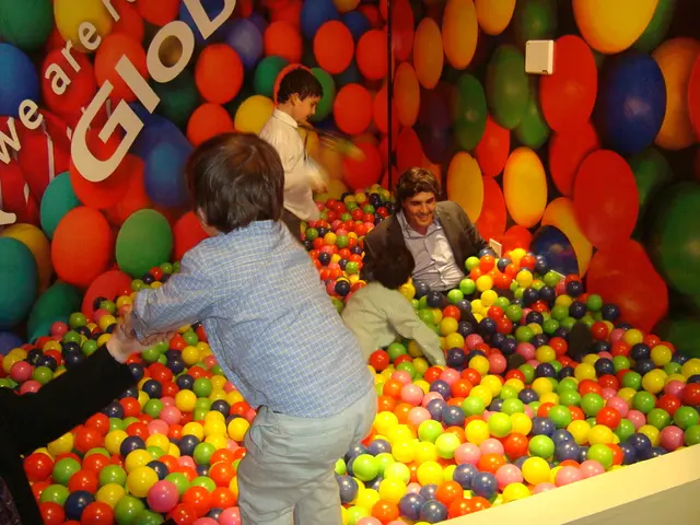 This is a fun ball pit. In this picture we can see a few people playing in a fun ball pit. There is...