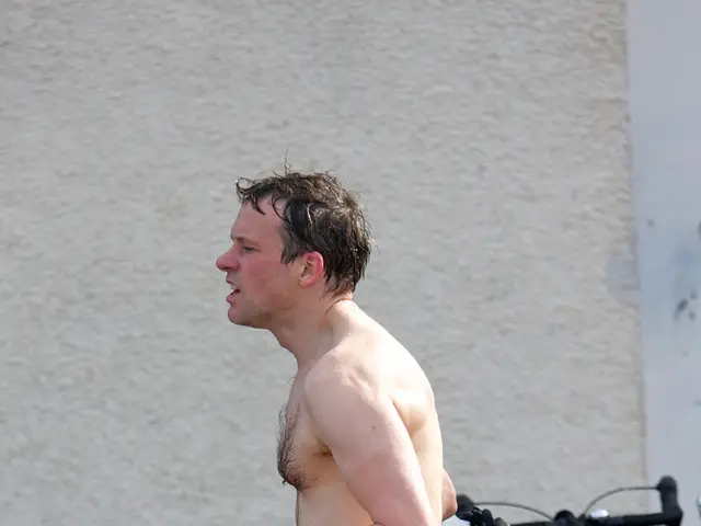 In this image we can see a person walking. In the back there are cycles. On the cycles there are...