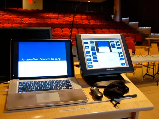 In this image there is laptop, monitor, remote, cloth, stick, cable, television arranged in a table...