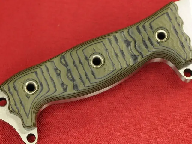 In this picture, we see a metal knife on the red color cloth.