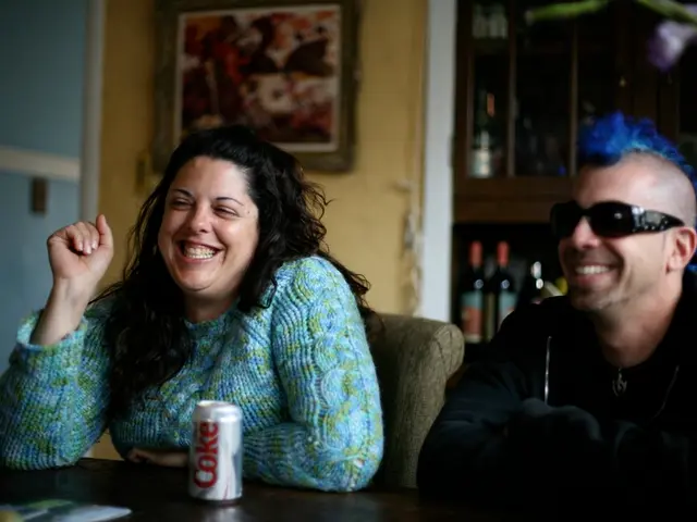 In the image we can see there are two people who are sitting on chair and on the table there is a...