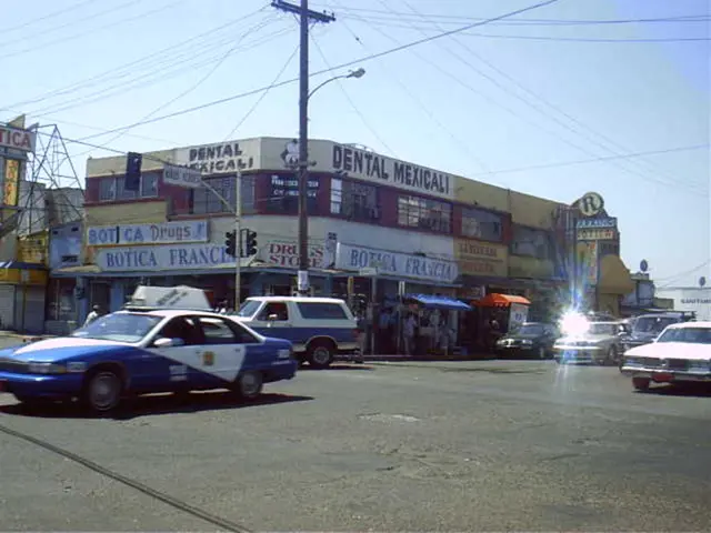 At the bottom of the image there is road. There are vehicles on the road. In the background of the...