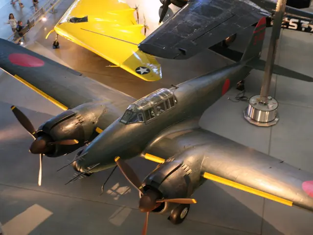 In this picture there are aircrafts. At the top left there are people and railing.