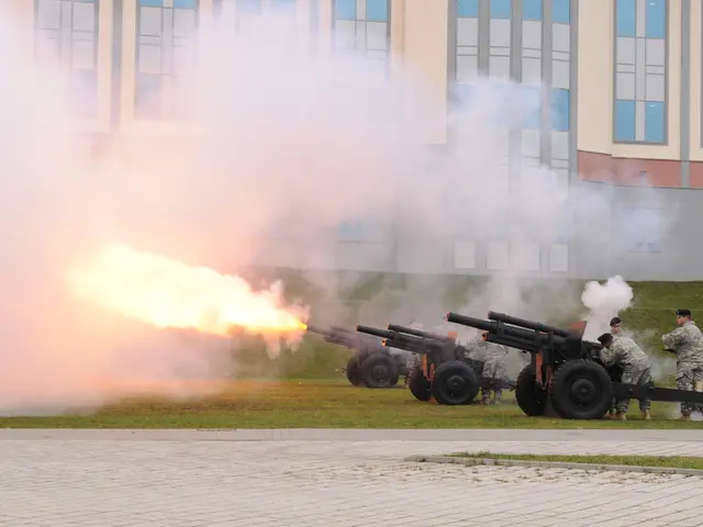 In this image we can see rifles on the ground, persons standing, buildings and floor.